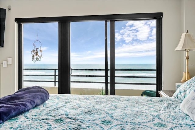 bedroom with multiple windows and a water view