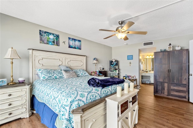 bedroom featuring ceiling fan, wood-type flooring, and a textured ceiling