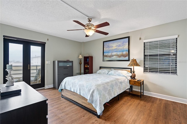 bedroom featuring hardwood / wood-style flooring, access to outside, a textured ceiling, and french doors