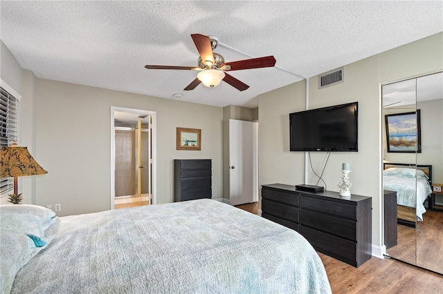 bedroom featuring ceiling fan, a textured ceiling, and light wood-type flooring