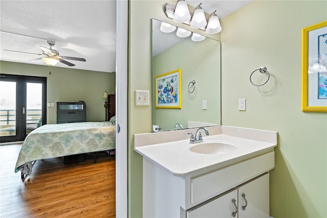 bathroom with french doors, ceiling fan, vanity, and a textured ceiling