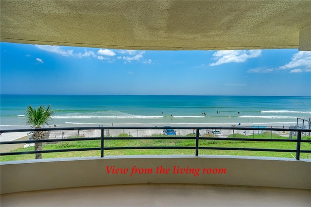 balcony with a water view and a beach view