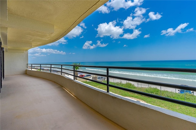 balcony featuring a beach view and a water view