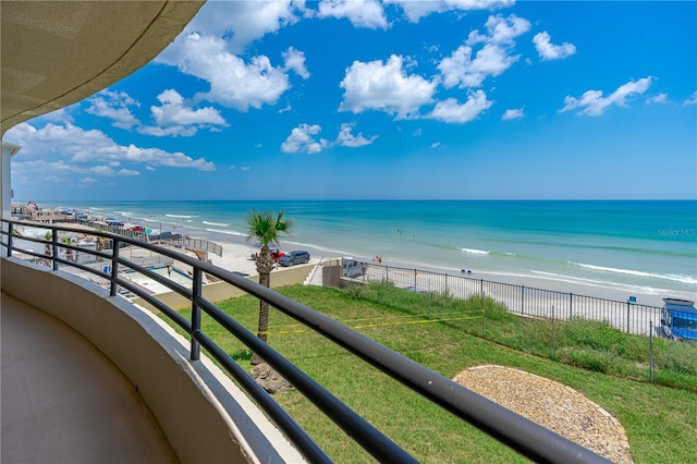 balcony with a water view and a view of the beach