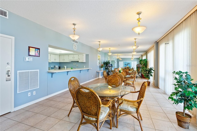 dining area with light tile patterned flooring and a textured ceiling