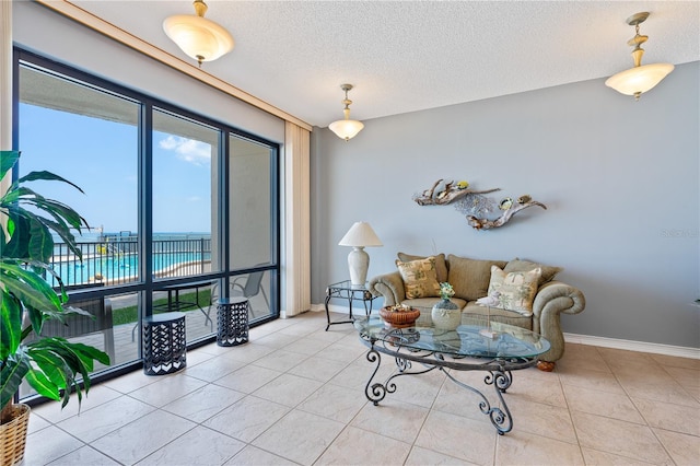 tiled living room featuring a water view and a textured ceiling