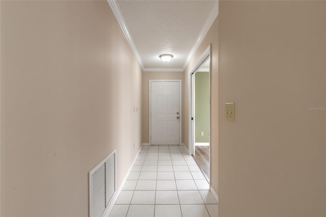 corridor featuring crown molding, light tile patterned floors, and a textured ceiling