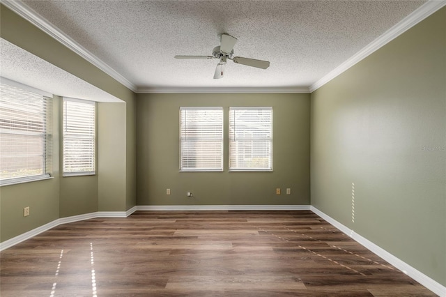 spare room featuring dark wood-type flooring, ceiling fan, and crown molding