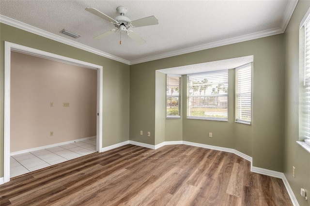 empty room featuring crown molding, ceiling fan, a textured ceiling, and light hardwood / wood-style flooring