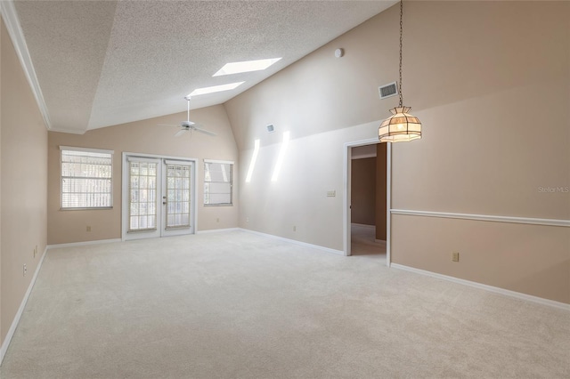 spare room with french doors, a skylight, a textured ceiling, ceiling fan, and carpet