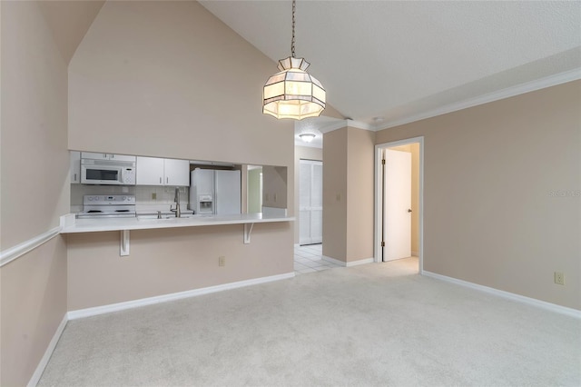 kitchen featuring white appliances, a breakfast bar area, white cabinetry, hanging light fixtures, and kitchen peninsula