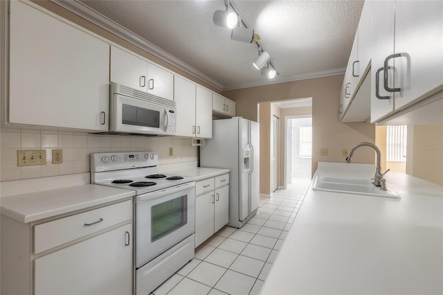 kitchen with sink, white cabinetry, crown molding, light tile patterned floors, and white appliances