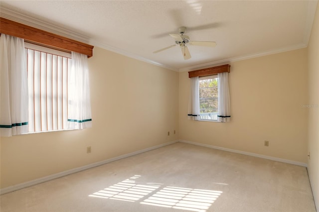 carpeted empty room with ceiling fan and ornamental molding