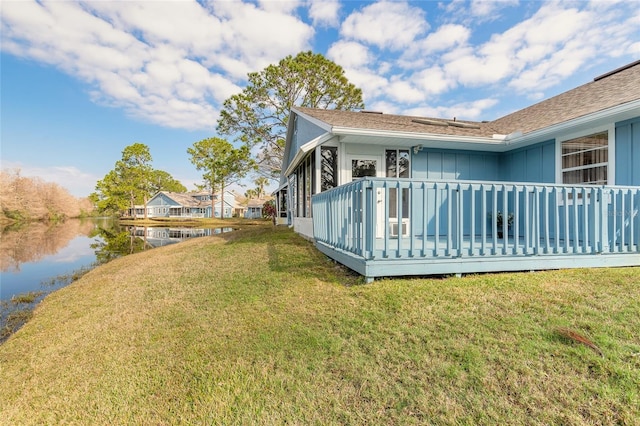 view of property exterior with a water view and a yard