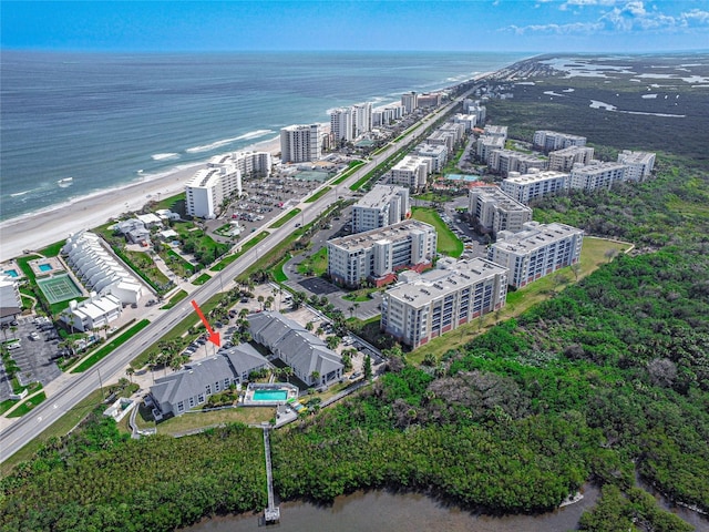 birds eye view of property with a water view and a beach view