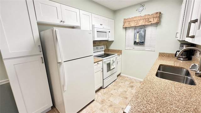 kitchen featuring light stone countertops, sink, white cabinets, and white appliances