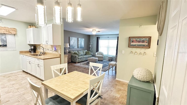 dining room featuring ceiling fan and sink