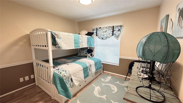 bedroom featuring wood-type flooring and a textured ceiling