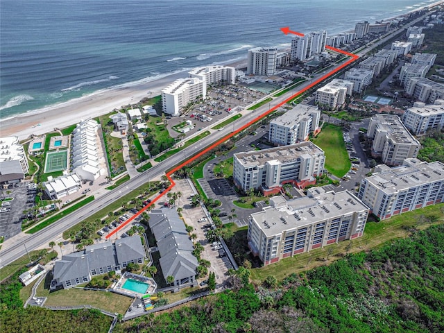 aerial view with a water view and a beach view