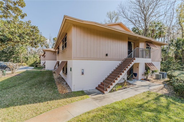 view of home's exterior featuring central AC unit and a lawn