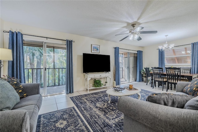 tiled living room featuring ceiling fan with notable chandelier and a textured ceiling