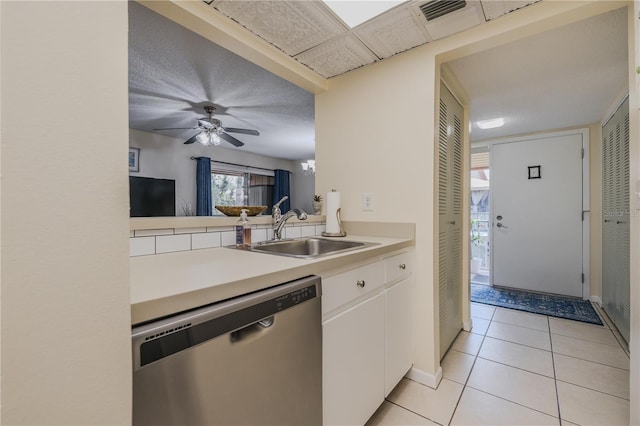 kitchen with light tile patterned flooring, sink, stainless steel dishwasher, ceiling fan, and white cabinets