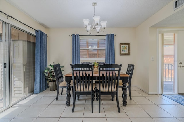 dining area with a chandelier and light tile patterned floors