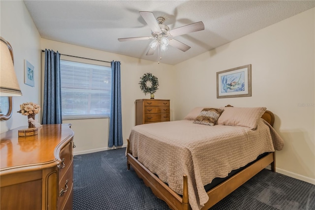 bedroom featuring a textured ceiling, ceiling fan, and dark colored carpet