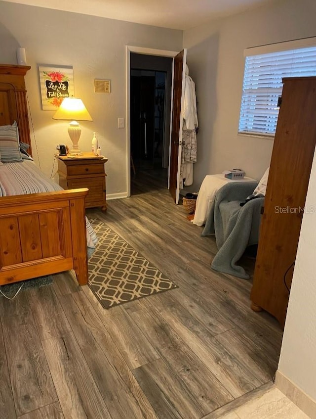 bedroom featuring baseboards and wood finished floors