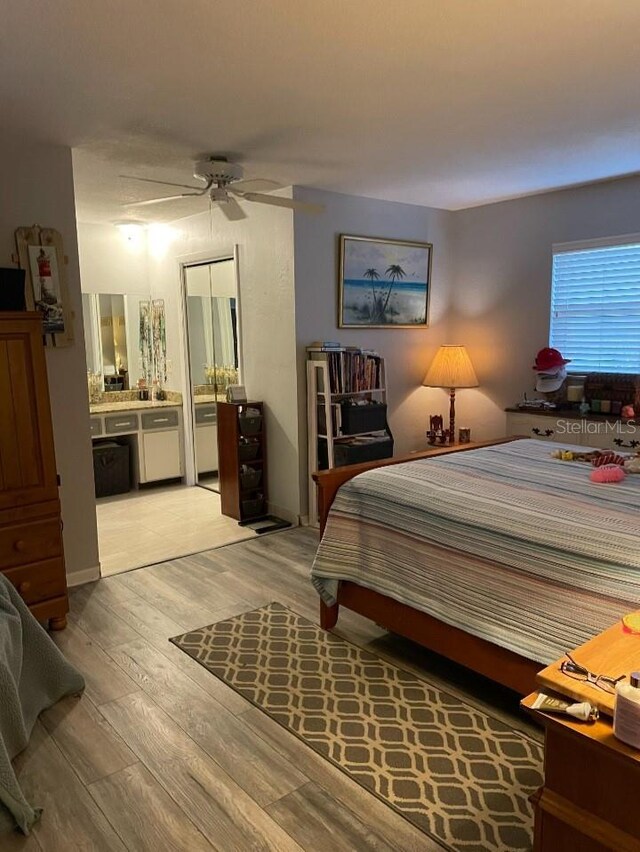 bedroom with ensuite bath, light wood-type flooring, and ceiling fan