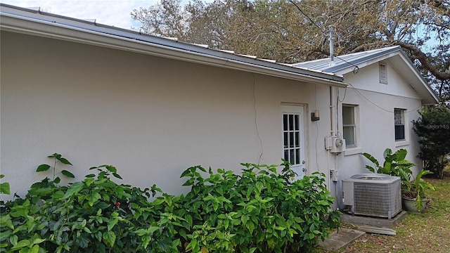 view of side of property with stucco siding and central AC unit