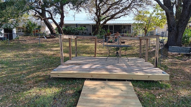 wooden terrace with a yard and fence