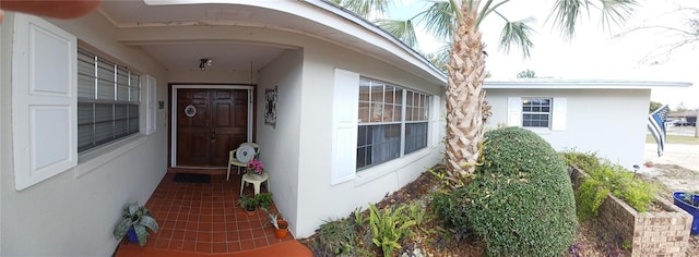 entrance to property featuring stucco siding