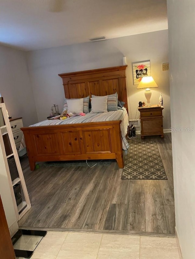 bedroom featuring wood finished floors, visible vents, and baseboards