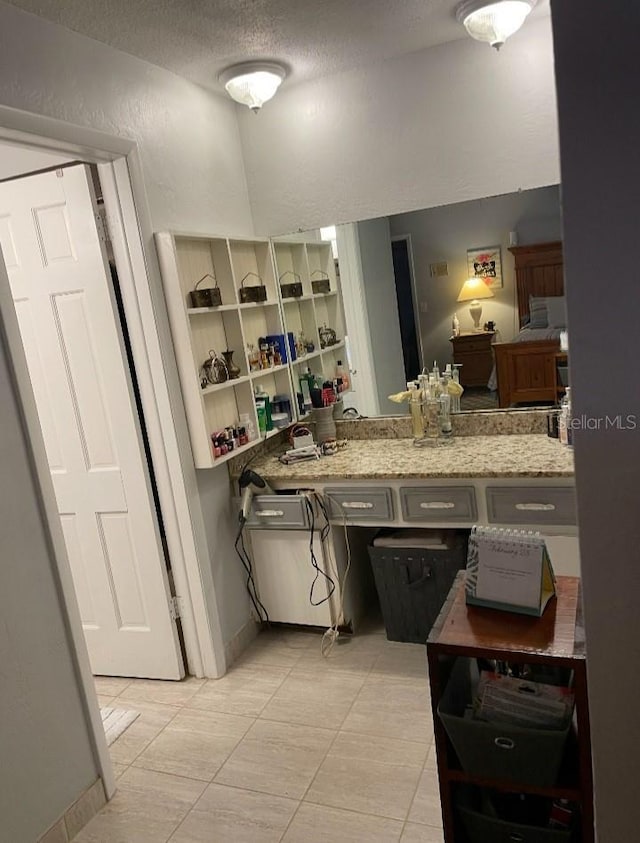 bathroom with a textured ceiling and a textured wall