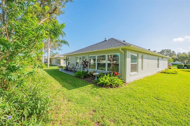 back of house featuring a patio and a lawn