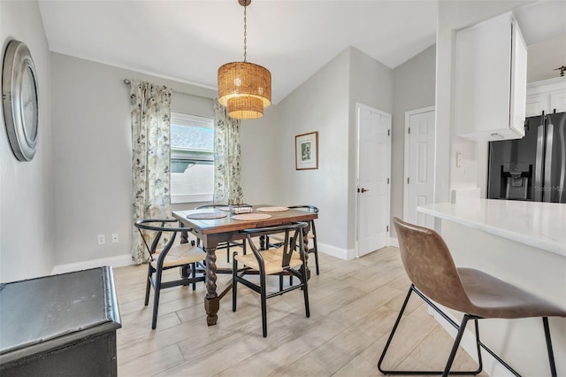 dining room featuring light wood-type flooring and baseboards