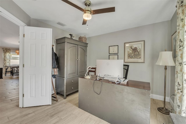 office space with light wood finished floors, baseboards, visible vents, and a ceiling fan