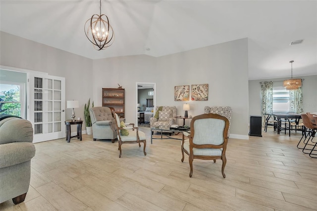 living area featuring a chandelier, light wood finished floors, visible vents, and baseboards