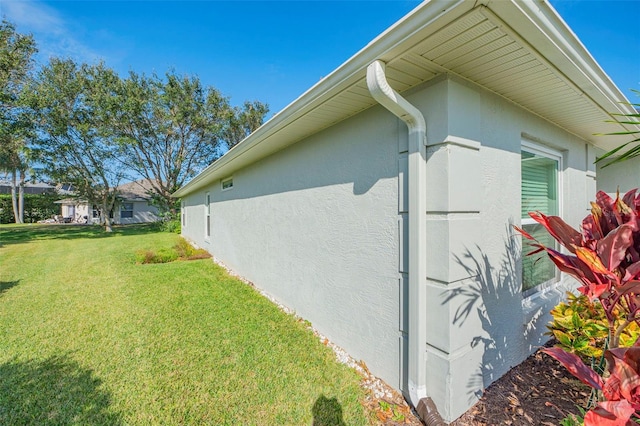 view of side of home featuring a yard and stucco siding