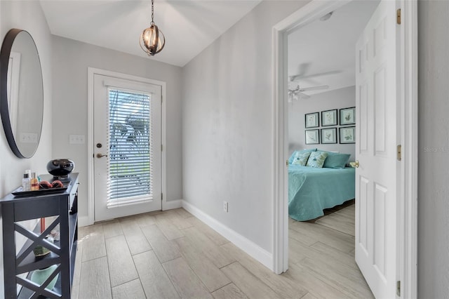 entryway featuring wood tiled floor, baseboards, and a ceiling fan