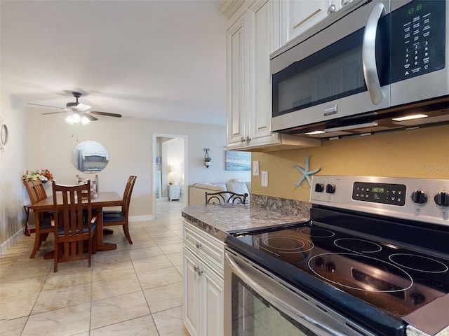 kitchen with ceiling fan, appliances with stainless steel finishes, light tile patterned floors, and white cabinets