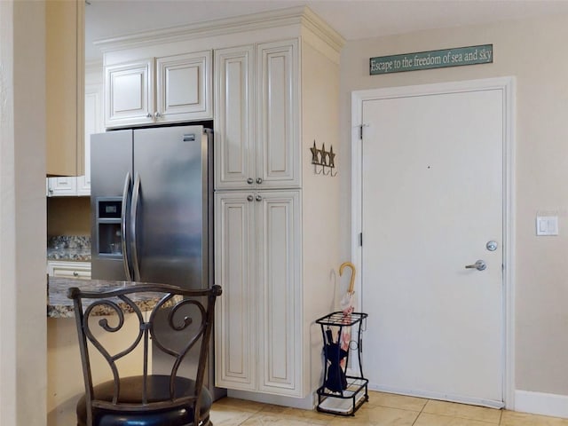 kitchen with stainless steel refrigerator with ice dispenser and light tile patterned flooring