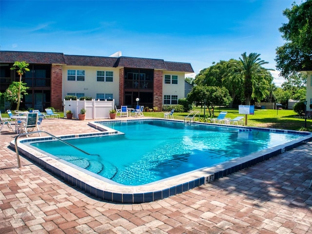 view of swimming pool with a yard and a patio area