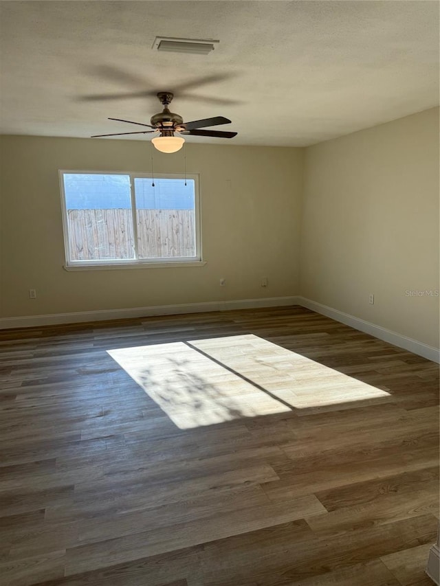 unfurnished room with dark wood-type flooring and a textured ceiling