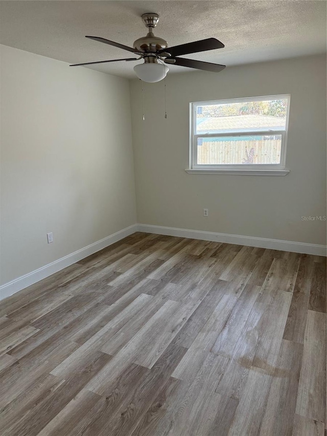 unfurnished room featuring light hardwood / wood-style floors and a textured ceiling