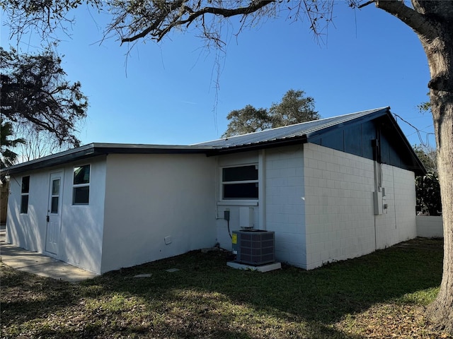 back of property with cooling unit and a yard