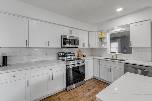 kitchen featuring stainless steel appliances, sink, and white cabinets