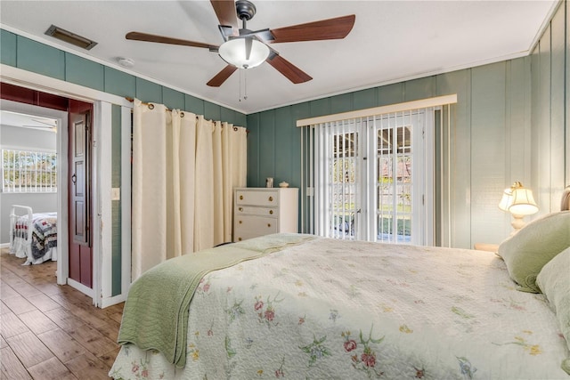 bedroom with hardwood / wood-style flooring, ceiling fan, and ornamental molding