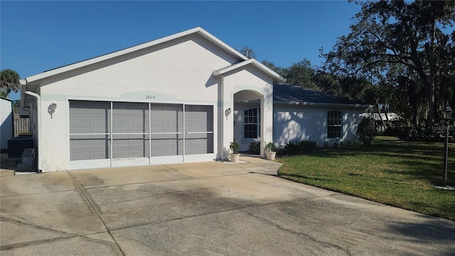 ranch-style home featuring a garage and a front lawn